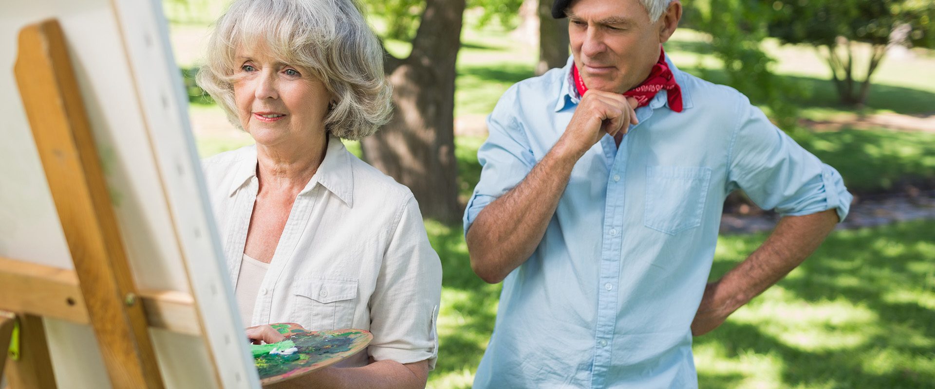 man-watching-mature-woman-paint-park