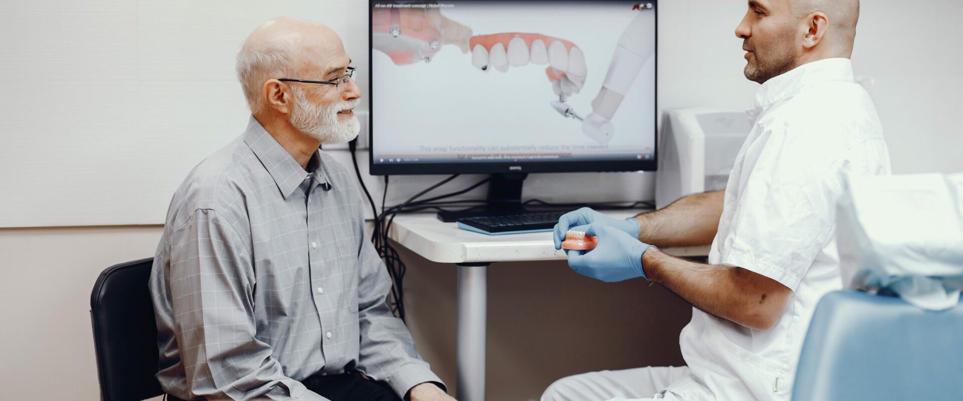 Handsome old man talking to the dendist. Two man in the dentist's office